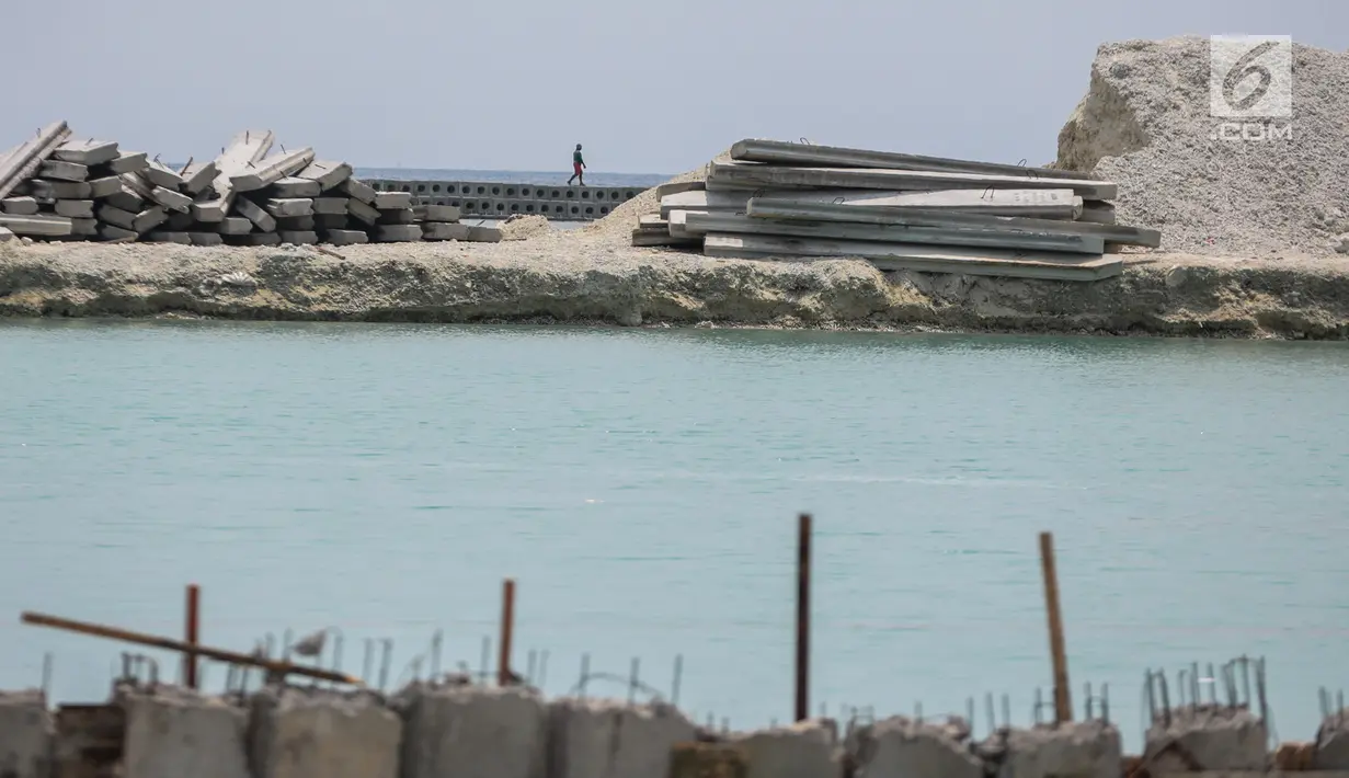 Seorang pekerja melintas di tengah proyek pembangunan dermaga di Pulau Pramuka, Kepulauan Seribu, Jakarta, Rabu (28/11). Proyek pembangunan dermaga yang sudah dimulai sejak tahun lalu itu terus dikebut pengerjaannya. (Liputan6.com/Faizal Fanani)