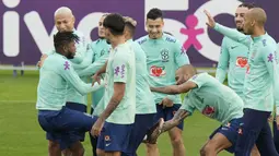 Sebagai pemain yang paling tua di tim, Dani Alves justru menjadi pemain yang paling usil dengan melepas sepatu Fred. Kejadian tersebut spontan membuat rekan-rekan yang berada disekitarnya tertawa. (AP/Luca Bruno)