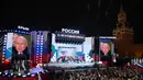 Di atas panggung, Putin berpidato penuh dengan semangat di hadapan ribuan orang yang berkumpul di Red Square. (NATALIA KOLESNIKOVA/AFP)