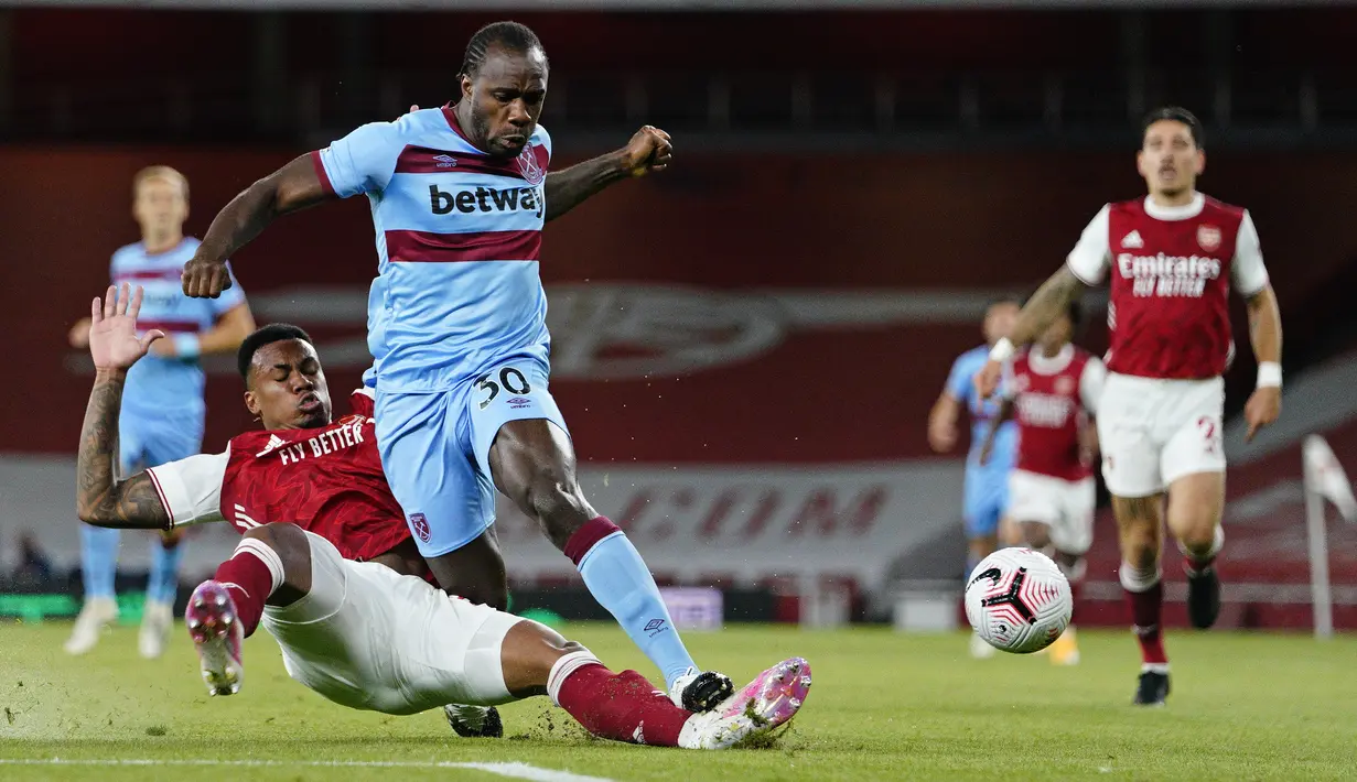 Gelandang West Ham, Michail Antonio membawa bola dari kawalan bek Arsenal,  Gabriel Magalhães pada pertandingan lanjutan Liga Inggris di Stadion Emirates di London, Inggris, Sabtu (19/9/2020). Arsenal menang tipis 2-1 atas West Ham. (Will Oliver/Pool via AP)
