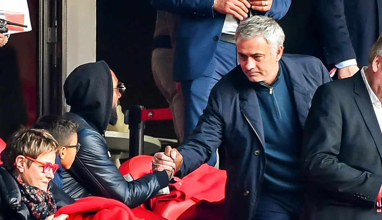 Mantan pelatih Manchester United Jose Mourinho (kanan) berjabat tangan dengan mantan pesepak bola Nicolas Anelka saat nonton Ligue 1 antara Lille melawan Montpellier di Stadion Pierre Mauroy, Villeneuve-d'Ascq, Prancis, Minggu (17/2).(Philippe HUGUEN/AFP)