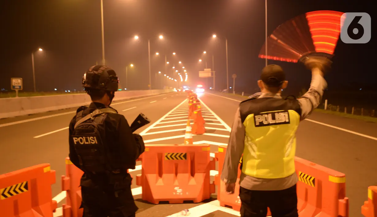 Petugas melakukan penyekatan arus mudik 2021 di gerbang pintu tol Pejagan, Brebes, Jawa Tengah, Jumat, (7/5/2021) Tengah Malam, H-5 peniadaan mudik Idul Fitri 1442H dengan petugas gabungan melakukan penjagaan di 6 titik dari kabupaten menjadi pintu masuknya Jawa Tengah. (merdeka.com/Imam Buhori)