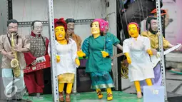 Delapan boneka yang digantukan pada tuas terlihat menari mengikuti alunan musik dangdut, bergoyang menghibur anak-anak di pelataran Museum Fatahillah, Jakarta, Kamis (17/12/2015). (Liputan6.com/Yoppy Renato)