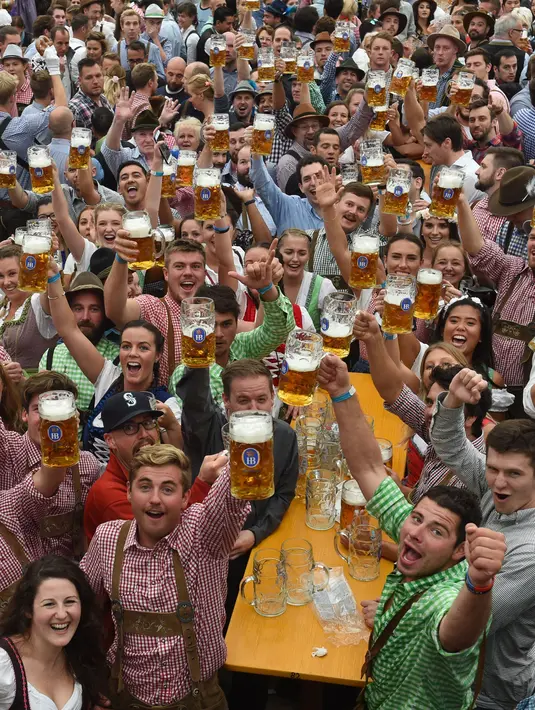 Para peserta mengangkat gelas bir saat pembukaan festival bir terbesar di dunia Oktoberfest ke-185 di Munich, Jerman, Sabtu (22/9). (Christof STACHE/AFP)