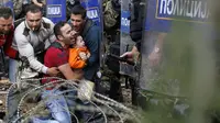 Terjadi keributan antara pengungsi dengan petugas kepolisian di perbatasan Makedonia. | via: Darko Vojinovic/Associated Press