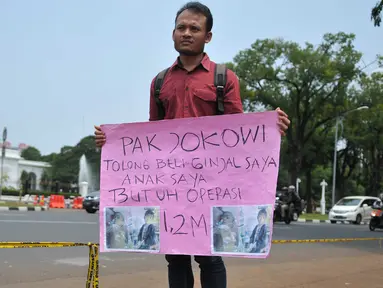 Susanto (28) melakukan aksi jual ginjal di depan Istana Merdeka, Jakarta, Jumat (20/11). Dalam aksinya, bapak muda itu meminta Presiden Jokowi membeli ginjalnya guna membiayai operasi transplantasi hati sang anak. (Liputan6.com/Gempur M Surya)