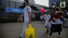 Sejumlah pemudik membawa barang bawaannya menuju bus untuk mudik bareng gratis BUMN di kawasan Jakarta, Rabu (27/4/2022). Total peserta program Mudik Aman Mudik Sehat Bersama BUMN 2022 mencapai 12.450 orang. (Liputan6.com/Faizal Fanani)