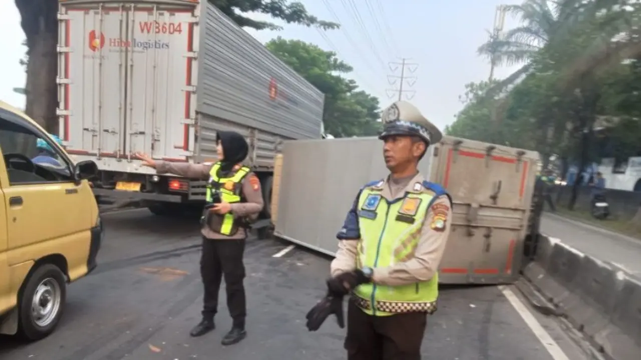 Sebuah truk boks ekspedisi bernomor polisi BK 8359 EX terguling di Jalan Daan Mogot KM 13, Cengkareng, Jakarta Barat pada Kamis (25/6/2026).