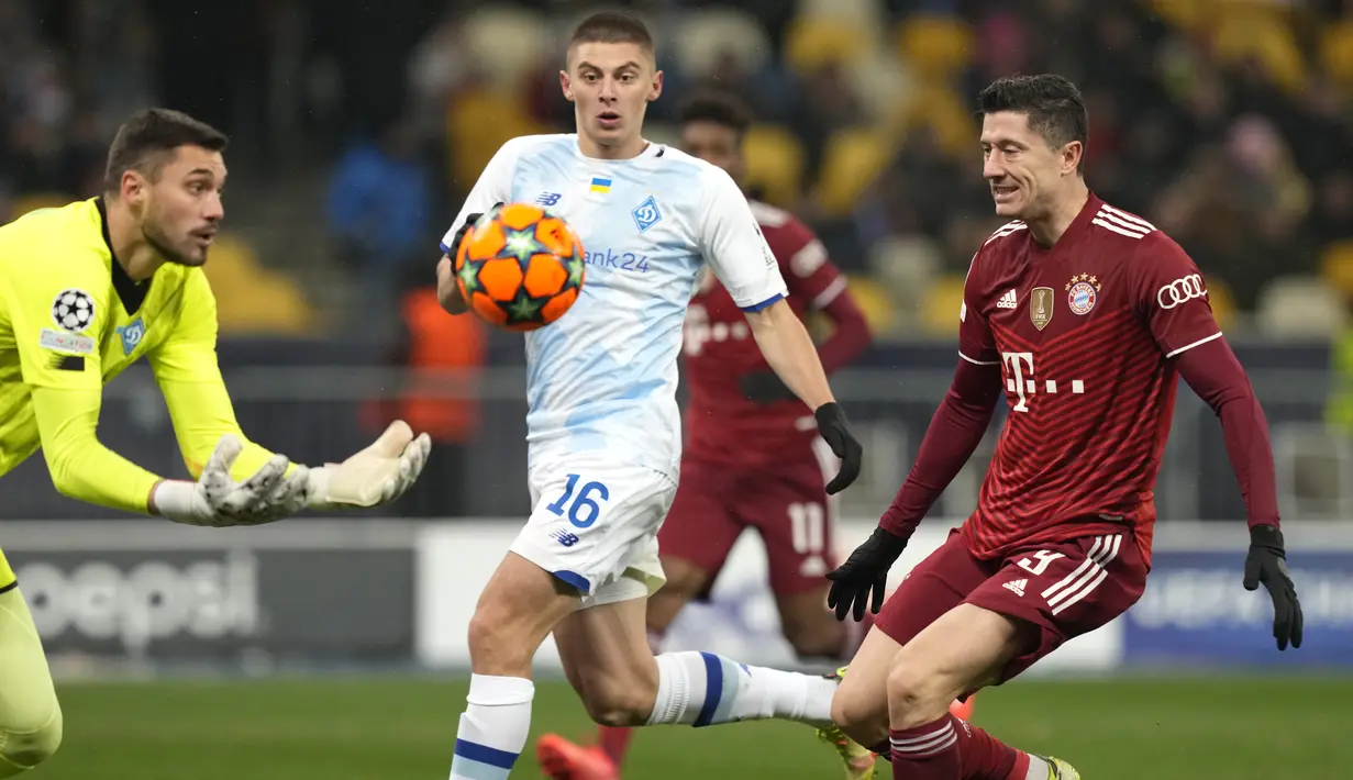 Kiper Dynamo Kiev Heorhiy Bushchan menghentikan bola yang dibawa oleh penyerang Bayern Munchen Robert Lewandowski pada matchday kelima Grup E Liga Champions di NSC Olympiyskiy, Rabu (24/11/2021). Bayern Munchen menang tipis saat bertamu ke markas Dynamo Kiev 2-1. (AP Photo/Efrem Lukatsky)