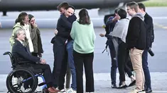 Pekerja bantuan Belgia, Olivier Vandecasteele (kiri tengah) disambut oleh keluarganya di landasan ketika dia turun dari pesawat militer Belgia di bandara militer Melsbroek di Melsbroek, Belgia, Jumat (26/5/2023). (Didier Lebrun/Pool Photo via AP)