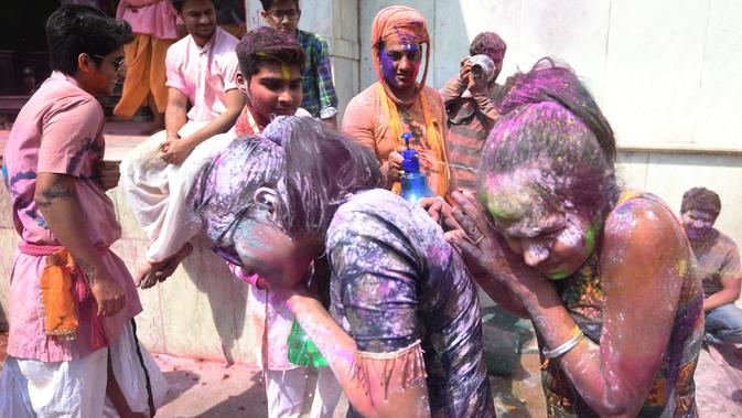 Umat Hindu merayakan Holi, festival warna musim semi, di sebuah kuil di desa Nandgaon, negara bagian Uttar Pradesh, 5 Maret 2020. Ribuan orang India menyambut musim semi pada Kamis (5/3) dengan merayakan Festival Holi yang identik dengan aksi saling melemparkan bubuk warna warni. (Money SHARMA/AFP)