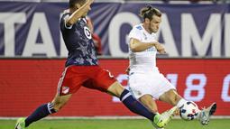 Pemain MLS All-Star, Matt Hedges, berusaha menghalau tendangan striker Real Madrid, Gareth Bale, pada laga persahabatan di Soldier Field, Chicago, Kamis (3/8/2017). Real Madrid menang 4-2 atas MLS All-Star melalui adu penalti. (AFP/Jonathan Daniel)