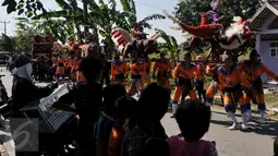 Para warga sekitar tampak melihat aksi dari pemain Sisingaan saat melewati ruas jalan di desa Jaya Bakti, Bekasi, Rabu (29/7/2015). Kesenian ini mempunyai ciri khas yaitu patung sisingaan atau binatang yang menyerupai singa. (Liputan6.com/JohanTallo)