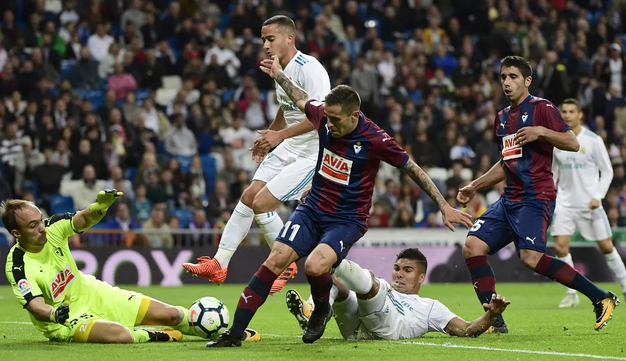 Kiper Eibar, Marko Dmitrovic (kiri) berusaha mengamankan bola dari kejaran para pemain Real Madrid pada lanjutan La Liga Santander di Santiago Bernabeu stadium, Madrid, (22/10/2017). Madrid menang 3-0. (AFP/Pierre-Philippe Marcou)