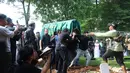 Isak tangis keluarga dan kerabat turut mengantarkan almarhum ke peristirahatan terakhir. Tampak dalam foto, kerabat dan keluarga membawa jenazah Epy Kusnandar di Tempat Pemakaman Umum (TPU) Jeruk Purut, Jakarta Selatan, Kamis (4/12/2025) pagi. (Kapanlagi.com/Budy Santoso)