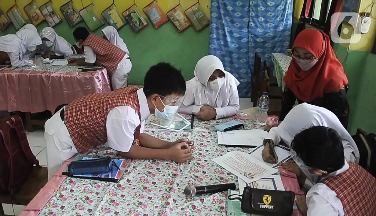 Para murid mengikuti pembelajaran tatap muka (PTM) terbatas di SDN Pisangan Baru 05 Pagi, Jakarta, Senin (8/11/2021). Pembekalan anak akan pemahaman protokol kesehatan di sekolah saat pandemi COVID-19 merupakan kewajiban orangtua dan guru. (merdeka com/Iqbal S. Nugroho)