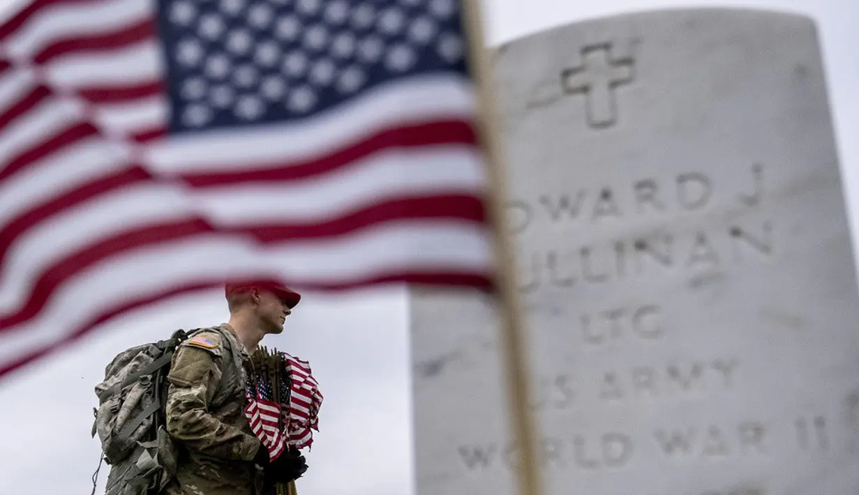 <p>Banyak sukarelawan memasang bendera Amerika Serikat pada makam personel militer di pemakaman nasional. (AP Photo/Andrew Harnik)</p>