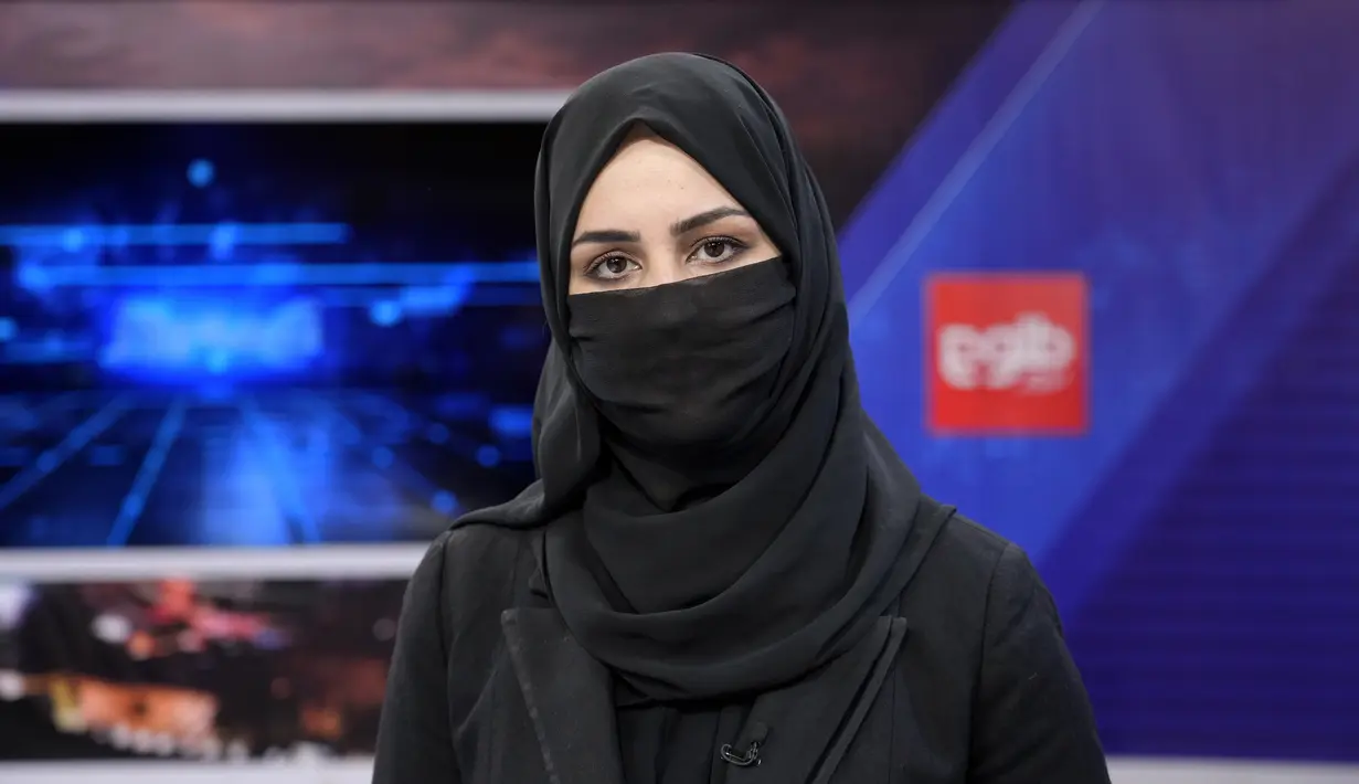 <p>Khatereh Ahmadi, seorang presenter televisi mengenakan penutup wajah saat membacakan berita di TOLO NEWS, di Kabul, Afghanistan, Minggu, 22 Mei 2022. Pada hari Minggu, presenter dan jurnalis perempuan menayangkan buletin berita di saluran-saluran terkemuka, mengenakan jilbab penuh dan cadar yang menutupi wajah sehingga hanya mata mereka yang terlihat. (AP Photo/Ebrahim Noroozi)</p>