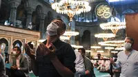 Umat Muslim, mengenakan masker sebagai pencegahan penyebaran COVID-19, berkumpul untuk salat Idul Adha di dalam era Bizantium Hagia Sophia, yang baru-baru ini dikonversi kembali ke masjid, di distrik bersejarah Sultanahmet Istanbul, Turki pada 31 Juli 2020. (Pool via AP)