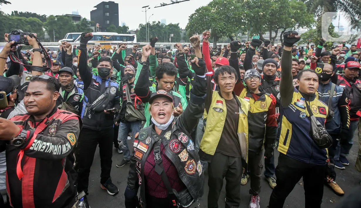 Pengemudi ojek online yang tergabung dalam Koalisi Ojol Nasional menggelar aksi di depan Gedung DPR RI, Jakarta, Senin (29/8/2022). Ratusan pengemudi ojek online tersebut menuntut beberapa hal di antaranya payung hukum dan legalitas profesi ojek online serta revisi potongan komisi pendapatan mitra. (Liputan6.com/Faizal Fanani)