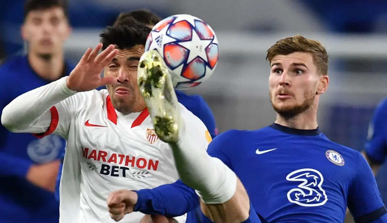 Striker Chelsea, Timo Werner, berebut bola dengan Gelandang Sevilla, Marcos Acuna, pada laga Grup E Liga Champions 2020/2021 di Stamford Bridge, Rabu (21/10/2020) dini hari WIB. Chelsea bermain imbang 0-0 atas Sevilla. (AFP/Glyn Kirk/pool)