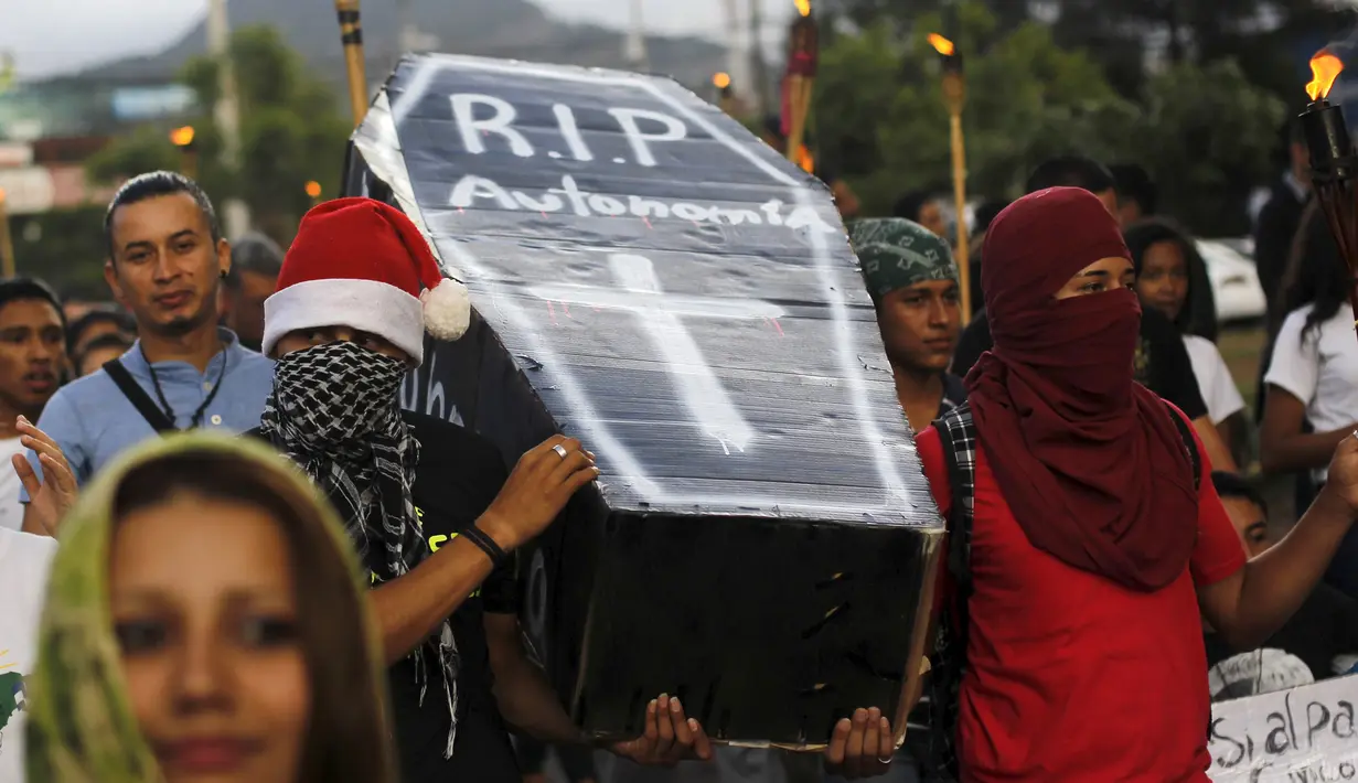 Para demonstran membawa peti mati bertuliskan "RIP Otonomi" saat unjuk rasa di Tegucigalpa, Jumat (24/7/2015).  Massa menuntut Presiden Juan Hernandez turun atas dugaan korupsi. (REUTERS/Jorge Cabrera)