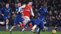 Striker Arsenal, Gabriel Martinelli, berebut bola dengan pemain Chelsea pada laga Premier League pekan ke-24 di Stamford Bridge, London, Rabu (22/1). Arsenal tahan imbang Chelsea 2-2. (AFP/Daniel Leal-Olivas)