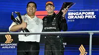 Pembalap Inggris peraih peringkat pertama Mercedes, George Russell (kanan), berpose di podium setelah balapan malam Formula Satu Grand Prix Singapura di Sirkuit Jalan Raya Marina Bay, Singapura, pada 5 Oktober 2025. (Lillian SUWANRUMPHA/AFP)