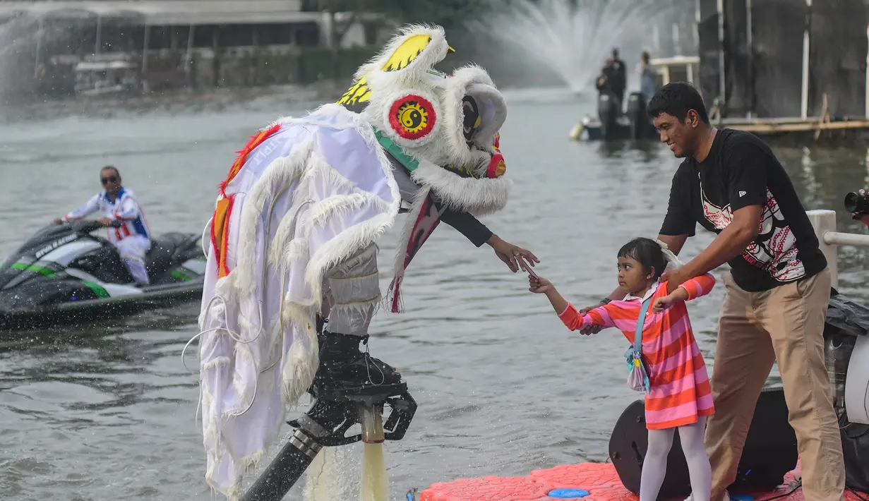 Sebelumya, pertunjukan ini sebelumnya telah sukses memukau penonton di Guangxi, China, dan Sydney, Australia, sebelum akhirnya hadir secara perdana di Jakarta. Tampak dalam foto, penampil mengenakan kostum barongsai beratraksi Aerial Lion Dance di Danau Senayan Park, Jakarta, 14 Februari 2026. (merdeka.com/Arie Basuki)