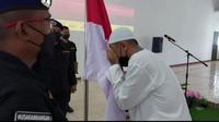 Napiter,  Basri, mencium Bendera Merah Putih di Lapas Nusakambangan sebagai bagian ikrar setia kepada NKRI, Sabtu (2/10/2021). (Foto: Humas Satgas Operasi Madago Raya).