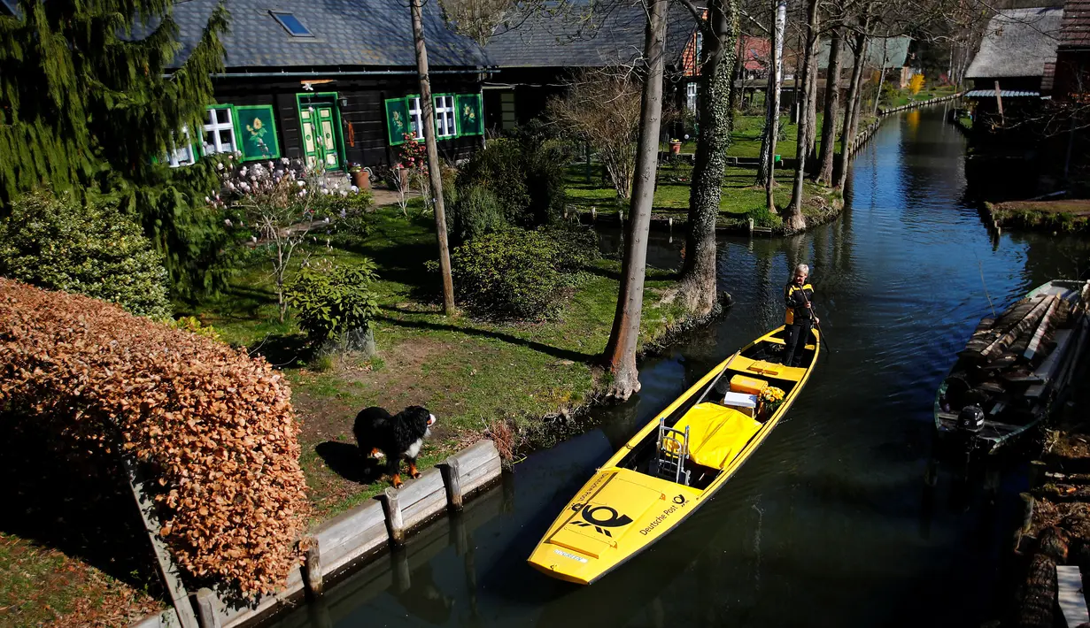Tukang pos wanita dari Deutsche Pos DHL, Andrea Bunar menggunakan perahu tradisional untuk mengantar surat dan paket di desa Spreewald di Lehde, 4 April 2019. Andrea Bunar menjadi satu-satunya tukang pos wanita Jerman yang mengantarkan surat dengan yang menggunakan perahu (REUTERS/Hannibal Hanschke)