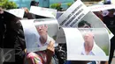 Massa menggunakan poster Menteri Yasonna Laoly untuk berlindung dari sinar matahari saat unjuk rasa di Kantor Kemenkumham Jakarta, Rabu (30/12). Aksi itu mempersoalkan legalitas kepengurusan PPP yang terbagi menjadi dua kubu. (Liputan6.com/Helmi Afandi)