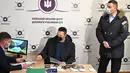 Wali Kota Kyiv Vitali Klitschko melihat saudaranya yang mantan petinju Ukraina Wladimir Klitschko mendaftar sebagai tentara cadangan di pusat perekrutan relawan, 2 Februari 2022. Wladimir beralasan cinta tanah air sehingga memaksanya untuk mempertahankan kemerdekaan Ukraina. (Genya SAVILOV/AFP)