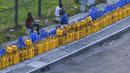 Orang-orang mengantre di sepanjang jalan untuk membeli tabung Liquefied Petroleum Gas (LPG) di dekat Stadion Kriket Internasional Galle di Galle, Sri Lanka, Selasa (28/6/2022). Warga Sri Lanka harus mengantre panjang demi mendapatkan elpiji untuk memasak di tengah krisis yang melanda negaranya. (ISHARA S. KODIKARA / AFP)