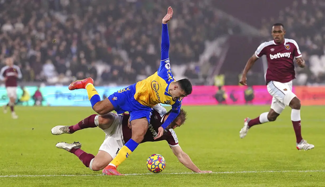Pemain Southampton Armando Broja (kiri) dilanggar oleh pemain West Ham United Craig Dawson yang mengakibatkan penalti pada pertandingan sepak bola Liga Inggris di London Stadium, London, Minggu (26/12/2021). Southampton menang 3-2. (Adam Davy/PA via AP)