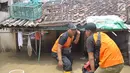 Petugas mengecek rumah yang tergenang banjir di kawasan Sawah besar Semarang, Jawa Tengah, Sabtu (8/12). Tingginya curah hujan dan banyaknya tumpukan sampah diduga menjadi penyebab jebolnya tanggul. (Liputan6.com/Gholib)