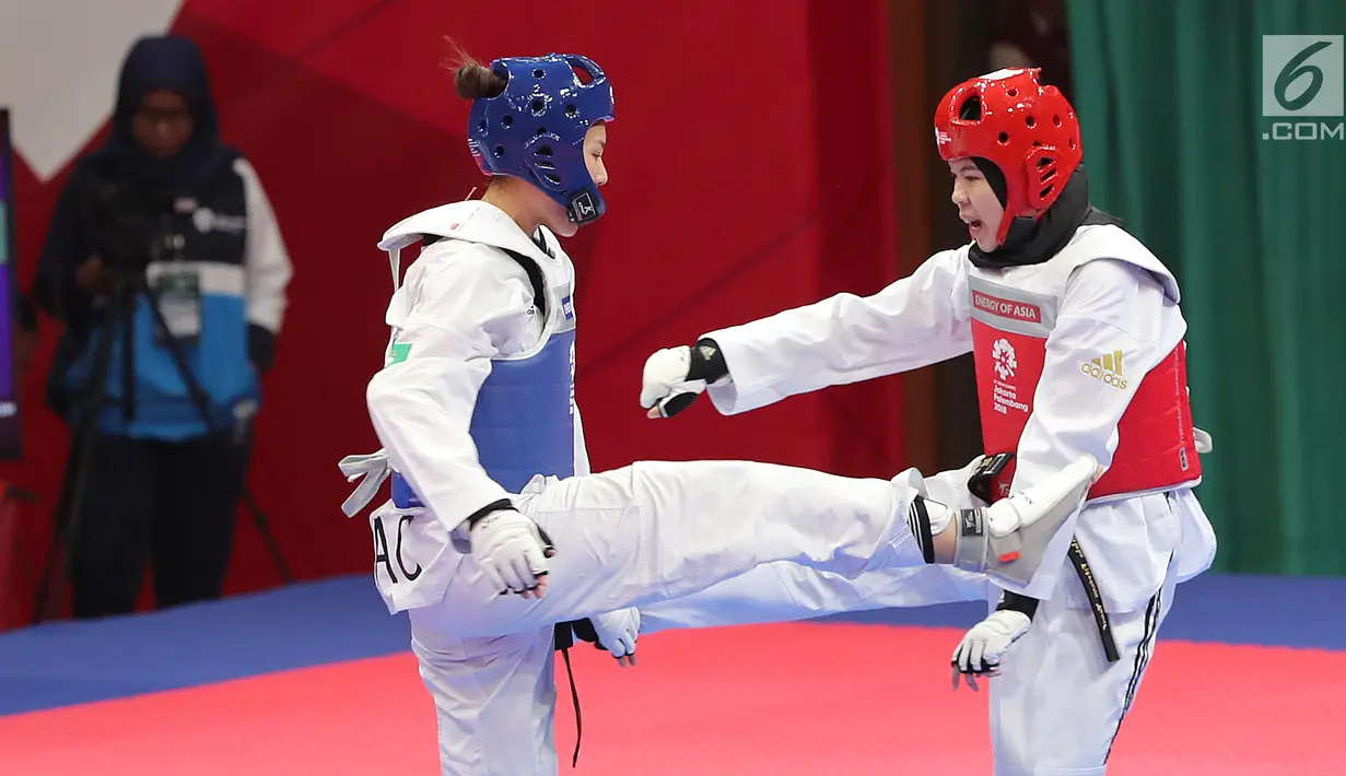 Atlet taekwondo putri Makau, Liu Qing melayangkan tendangannya ke arah Fitriyana Yusuf dari Indonesia pada babak 16 besar di Jakarta Convention Center (JCC), Senin (20/8). Fitriyana kalah tipis 21 - 25 pada kelas Wanita 67 kg. (Liputan6.com/Fery Pradolo)
