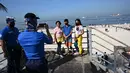 Warga berfoto di jembatan penyeberangan yang menghadap ke Manila baywalk dolomite beach di sepanjang boulevard Roxas, kota Manila, Filipina pada Minggu (17/10/2021). Sehari sebelumnya, pihak berwenang melonggarkan pembatasan karantina di ibu kota negara itu. (Ted ALJIBE / AFP)