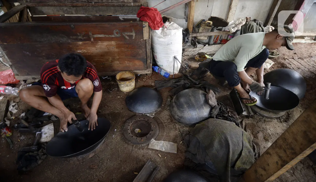 Perajin menyelesaikan pembuatan wajan yang terbuat dari pelat besi di Desa Cibadak, Tanah Sareal, Kabupaten Bogor, Jawa Barat, Rabu (5/8/2020). Pemerintah akan memberi bantuan Rp 2,4 juta dan kredit bunga rendah kepada UMKM untuk membantu pemulihan ekonomi nasional. (merdeka.com/Dwi Narwoko)