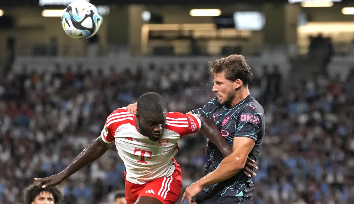 Bek Manchester City, Ruben Dias (kanan) berduel udara dengan bek Bayern Munchen, Dayot Upamecano pada laga pramusim 2023/2024 bertajuk Audi Football Summit di Stadion Nasional Tokyo, Jepang, Rabu (26/7/2023) malam WIB. (AP Photo/Shuji Kajiyama)