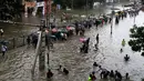 Sejumlah orang berjalan menerobos banjir akibat hujan lebat mengguyur kota Mumbai di India, Selasa (29/8). Banjir dan buruknya cuaca juga membuat penerbangan dialihkan dan perjalanan kereta api lokal terhambat. (AP Photo/Rajanish Kakade)