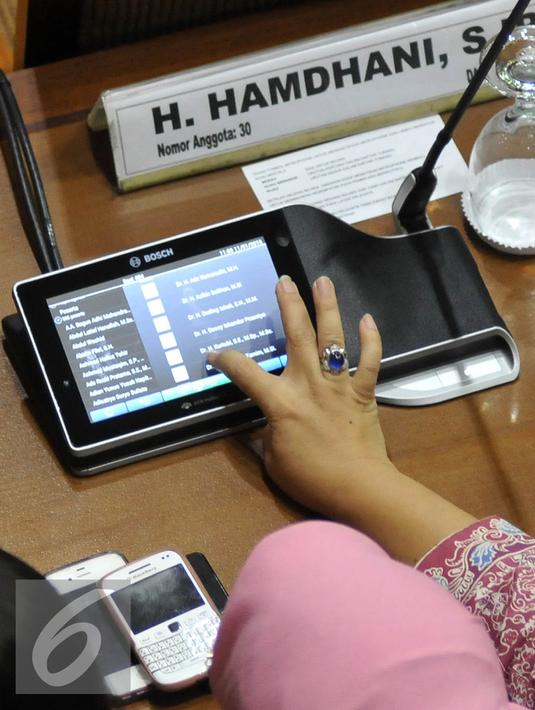 Anggota DPR terlihat mengunakan mikrofon baru saat Sidang Paripurna di Jakarta, Senin (11/1). Mikrofon baru yang termasuk dalam paket pengadaan Conference System Ruang Rapat Paripurna Gedung Nusantara II senilai Rp34,4 Miliar.  (Liputan6.com/JohanTallo)