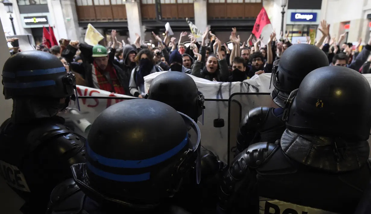 Polisi berjaga saat aksi demonstran di dekat Stasiun Saint-Lazare, Paris, Perancis, Selasa (12/4). Demonstran menentang reformasi hukum perburuhan yang dirancang pemerintah Perancis. (AFP Photo/ Dominique Faget)