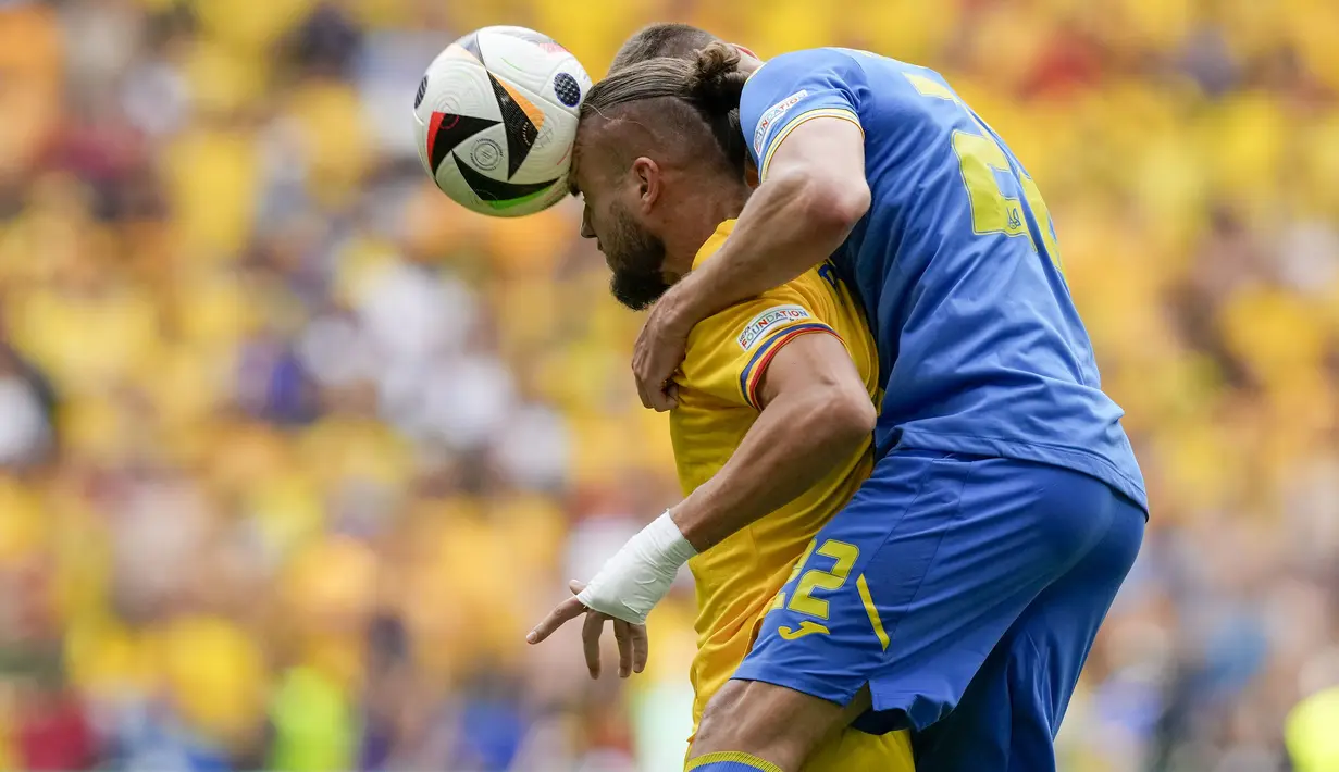 Striker Timnas Rumania, George Puscas (kiri) berebut bola dengan bek Timnas Ukraina, Mykola Matviyenko pada laga Grup E Euro 2024 di Allianz Arena, Munchen, Jerman, Senin (17/6/2024). (AP Photo/Antonio Calanni)