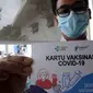 Seorang pria menunjukkan Kartu Vaksinasi COVID-19 saat kegiatan vaksinasi di Puskemas Jagakarsa, Jakarta Selatan, Kamis (14/1/2020). Sejumlah Puskesmas di Jabodetabek mulai melakukan vaksinasi COVID-19 pada hari ini. (merdeka.com/Arie Basuki)