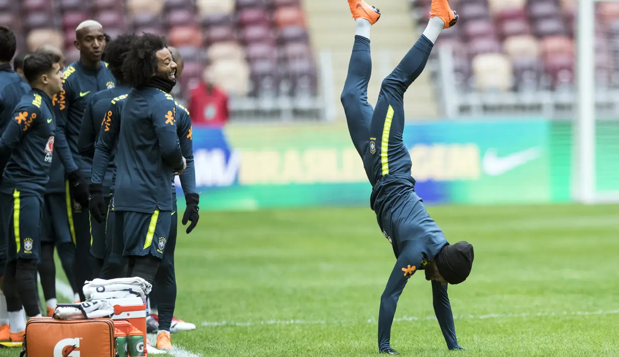 Aksi pemain Brasil, Dani Alves (kanan) saat berjalan dengan tangan pada sesi latihan di Stadion Olimpiyskiy Luzhniki, Moskva, Rusia, (22/3/2018). Brasil akan melawan Rusia pada laga uji coba 23 Maret. (AP/Pavel Golovkin)