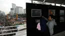 Warga melihat pameran foto kemajuan pembangunan MRT di Jembatan Penyebrangan Orang Bundaran Hotel Indonesia, Jakarta, Minggu (7/5). Pameran bertema Aku, Kamu, Kita #UbahJakarta. (Liputan6.com/Helmi Fithriansyah)