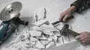 Seniman Italia, Nazareno Biondo menggunakan alat bantu mesin potong, pahat, dan palu saat menyelesaikan replika mobil Fiat 500 berbahan dasar marmer Carrara di Cafasse, dekat Turin, Italia, Rabu (16/5). (MARCO BERTORELLO/AFP)