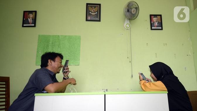 Guru Wahyu Adi Prasetyo (kiri) dan Rantiyani mengajar secara online di sekolah tunanetra Yayasan Raudlatul Makfufin, Buaran, Serpong, Tangerang Selatan, Banten, Senin (10/8/2020). Keterbatasan kuota internet membuat para guru membatasi waktu belajar. (merdeka.com/Dwi Narwoko)