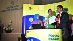 Presiden Joko Widodo (kanan) dibantu petugas mengisi surat pemberitahuan tahunan (SPT) pajak penghasilan menggunakan sistem e-filling di Kantor Pusat Ditjen Pajak Jakarta, Kamis (19/3/2015). (Liputan6.com/Faizal Fanani)